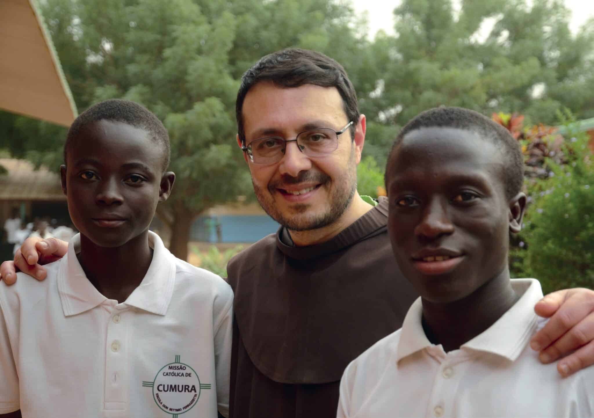 fra Pietro Pagliarini con due studenti della scuola di Cumura in Guinea Bissau. Immagine usata per la pagina del sito "Santuario di motta di livenza per la sezione dedicata ai conventi della pagina "Chi Siamo - Conventi e missioni dei frati minori"